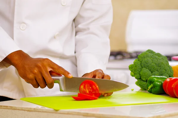 Detailní záběr rukou šéfkuchař stříhání barevné zeleniny v profesionální kuchyni, bílé pozadí — Stock fotografie