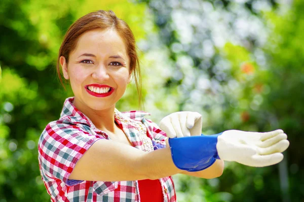 Mulheres vestidas com roupas coloridas colocando luvas de trabalho — Fotografia de Stock