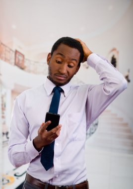 Düşünceli vücut dili sırasında elinde cep telefonu tutarak poz gömlek ve kravat giyen yakışıklı adam