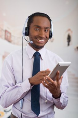 Yakışıklı adam mikrofon, beyaz çizgili gömlek ve kravat ile kulaklık giyen, elinde tablet tutarak poz, etkileşim gülümseyen