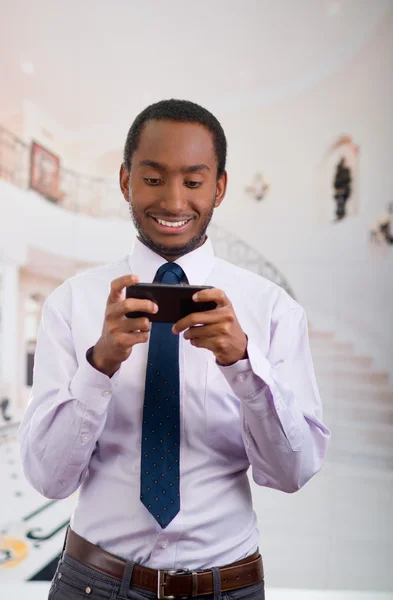 Knappe man dragen shirt en stropdas houden van mobiele telefoon schrijven tekstbericht — Stockfoto