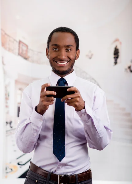 Красавчик в рубашке и галстуке, который пишет смс на мобильный телефон. — стоковое фото