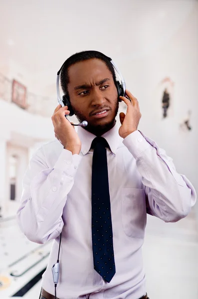 Hombre guapo con auriculares con micrófono, camisa y corbata de rayas blancas, interactuando activamente, concepto de negocio — Foto de Stock