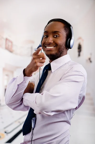 Handsome man wearing headphones with microphone, white striped shirt and tie, interacting confident, business concept — Stock Photo, Image
