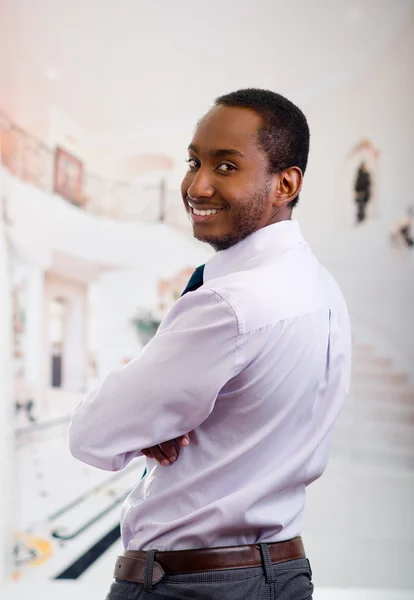 Hombre guapo con camisa y corbata posando con la espalda a la cámara, gira la cabeza sonriendo, concepto de negocio — Foto de Stock