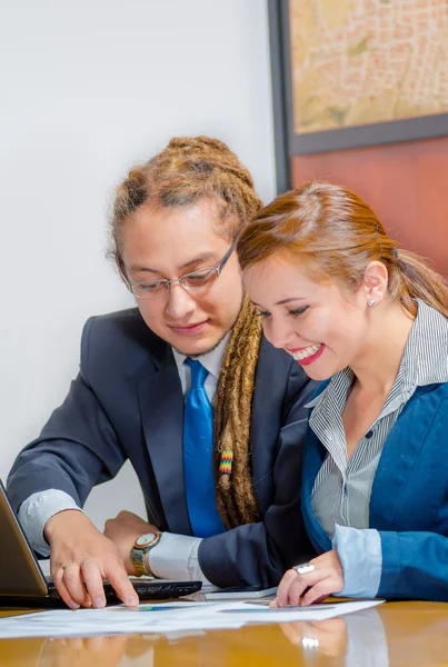 Stilig ung man bär formella passar sittande med ganska kvinnliga medarbetare tittar på skärmen och diskuterar mellan varandra, office manager koncept — Stockfoto