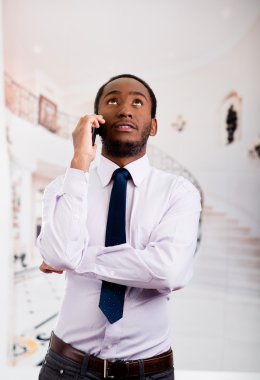 Gömlek ve kravat lobi alanında cep telefonu, iş kavramı üzerinde konuşurken ayakta giyen yakışıklı adam