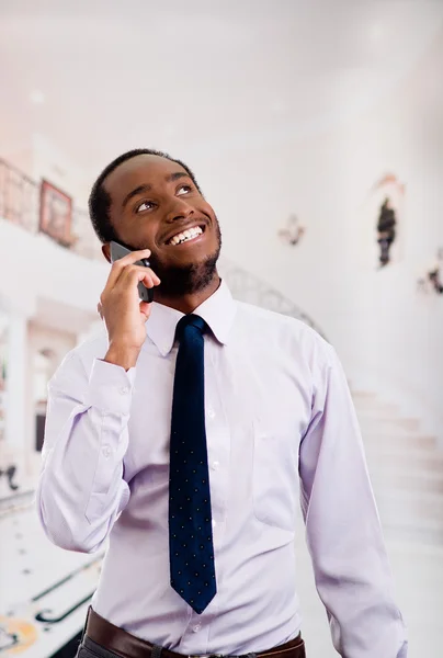 Beau homme portant chemise et cravate debout dans le hall parler sur téléphone mobile, concept d'entreprise — Photo