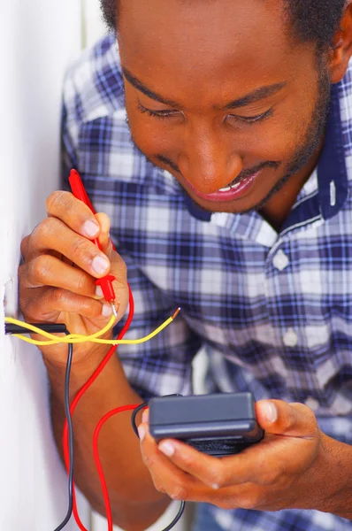 Mann in weißem und blauem Hemd arbeitet mit Multimeter-Elektriker-Konzept an elektrischen Steckdosen — Stockfoto