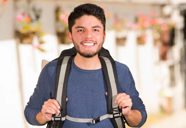 Young happy man wearing casual clothes and backpack posing for camera, smiling, garden environment, backpacker concept — Stock Photo, Image