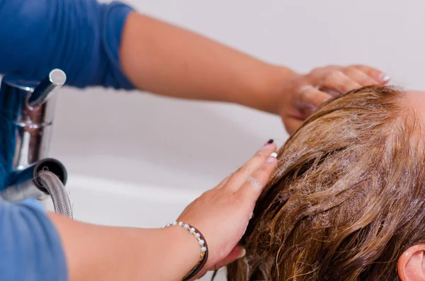 美容院のサルーンの中で、長い染めの髪をシャンプーで洗う手 — ストック写真