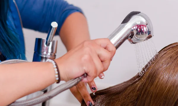 All'interno del salone di parrucchiere, le mani della donna lavano i capelli lunghi con acqua fredda — Foto Stock