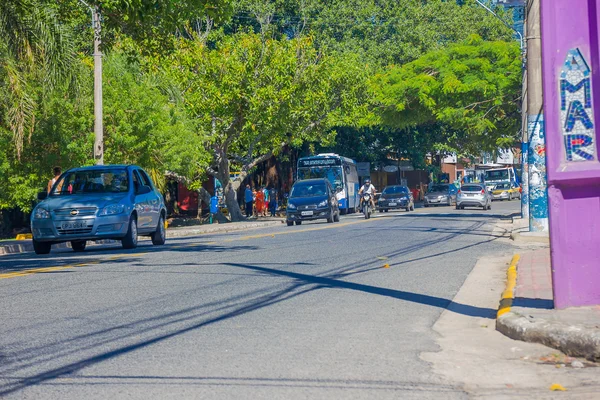 Florianopolis, Brazilië - 08 mei 2016: sommige auto's rijden op de straat, voetgangers wachten op de bus en sommige grote bomen op de stoep — Stockfoto