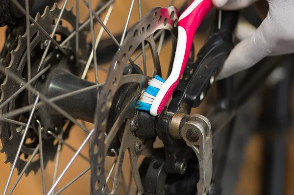 特写镜头详细的看看自行车车轮换挡力学在维修，牙刷刷牙在部分 — 图库照片