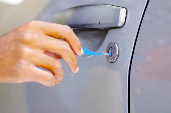 Primeros planos manos de cerrajero utilizando herramientas de selección para abrir la puerta del coche con llave — Foto de Stock