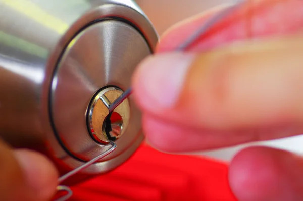 Ręce zbliżenie ślusarz za pomocą metalowych wybrać narzędzia wobec otworzyć zamknięte drzwi — Zdjęcie stockowe