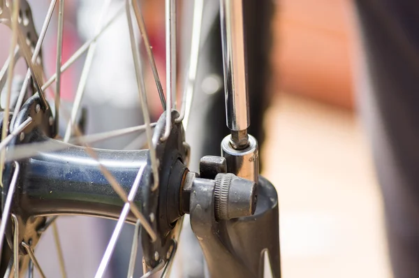 Closeup multi schroevendraaier bezig met mechanische onderdelen naast wiel spaken — Stockfoto