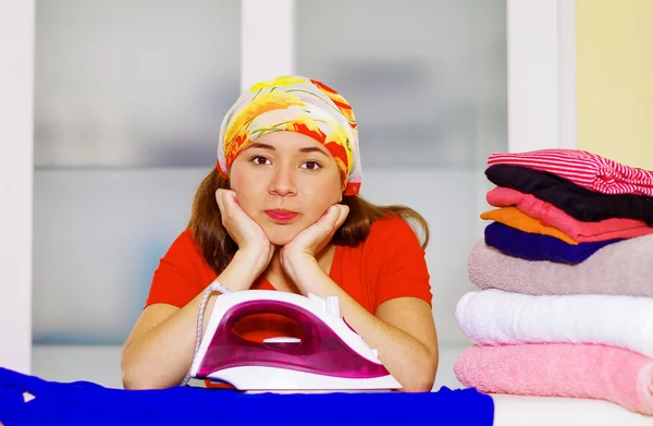 Mujer encantadora joven con pañuelo de cabeza de colores descansando cabeza en sus propias manos mirando a la cámara, concepto de tareas domésticas de lavandería — Foto de Stock