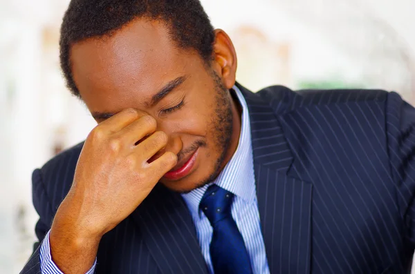 Man wearing elegant blue business suit bending head forward into fingers of right hand, frustrated body language — Stock Photo, Image