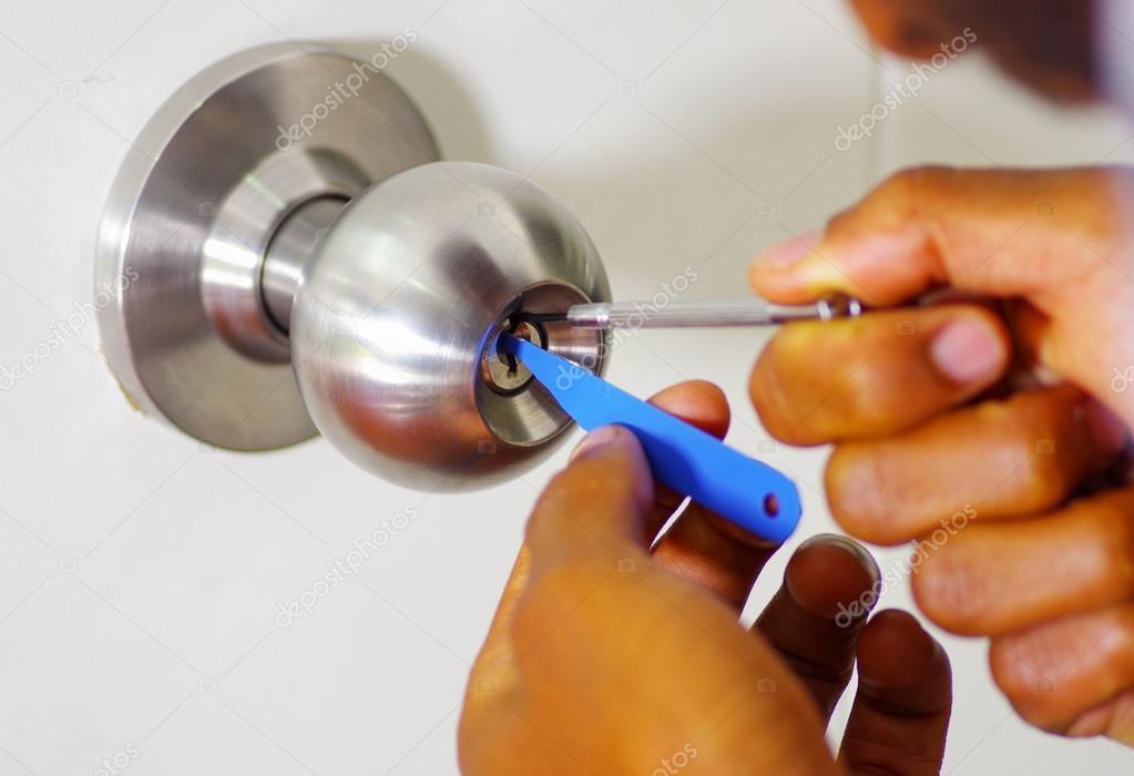 Closeup Hands Of Locksmith Using Pick Tools To Open Locked