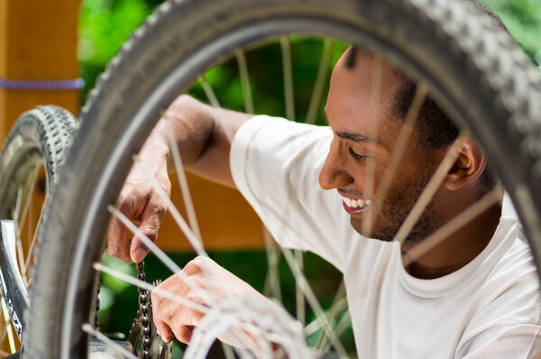 Man wearing white shirt happy working on repairing bicycle mechanics using screwdriver tool