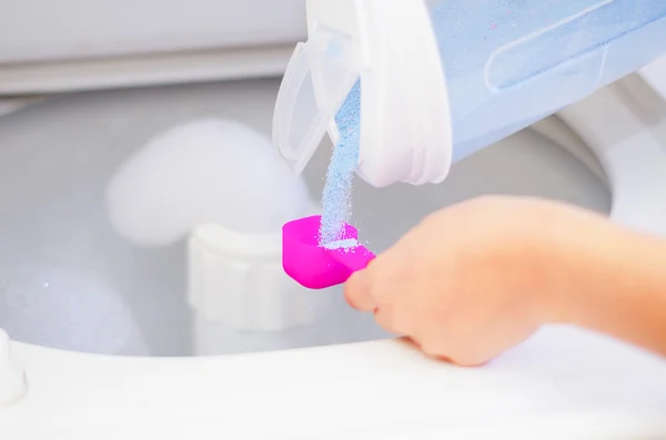 Gros plan womans mains verser détergent dans sur mesure tasse pour machine à laver, concept de ménage blanchisserie — Photo