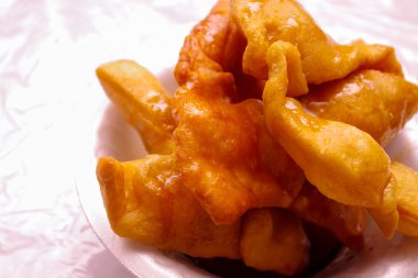 Beyaz bir plastik tabakta bal ıslatılmış hizmet bunuelos, yakın çekim