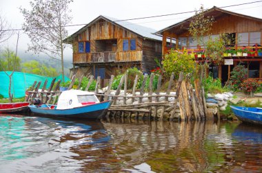 Pasto, Kolombiya - 3 Temmuz 2016: bazı ahşap evlerin önünde mavi ve beyaz küçük tekne parken