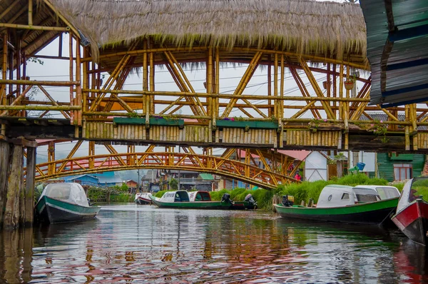 Pasto, Colombia-3 juli 2016: sommige houten bruggen staan over een aantal boten op een rivier in de buurt van het meer van La Cocha — Stockfoto