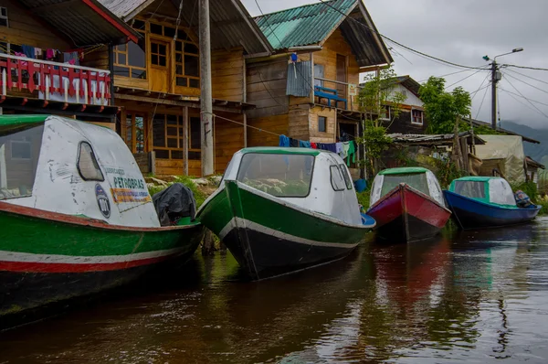 Pasto, Colombia - 3 juli 2016: sommige kleurrijke boten geparkeerd naast een shore en sommige huizen in la cocha lake — Stockfoto