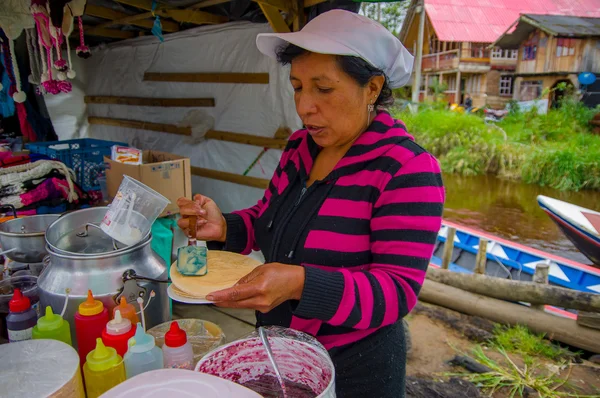 Pasto, Colombia - 3 juli 2016: oidentifierad kvinna att lägga till lite karamell i en wafer i ett läge nära la cocha sjö — Stockfoto