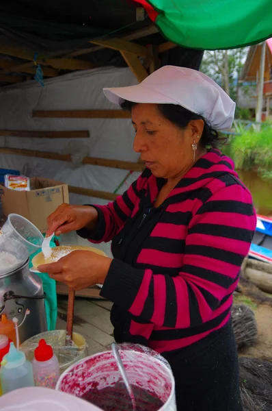 PASTO, COLOMBIA - 3 LUGLIO 2016: donna non identificata che aggiunge del cocco a un dessert — Foto Stock