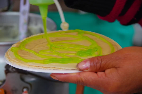 PASTO, COLOMBIA - JULY 3, 2016: woman preparing a wafer with kiwi syrup in a location close to la cocha lake — Stock Photo, Image