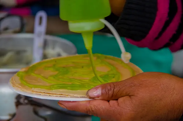 Pasto, Colombia - 3 juli 2016: kvinna lägga några kiwi sirap till en wafer i ett läge nära la cocha sjö — Stockfoto