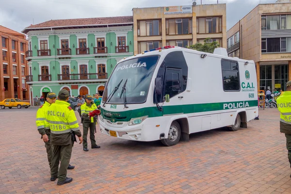 PASTO, COLOMBIA - 3 de julio de 2016: agentes de policía no identificados de pie junto a un autobús policial estacionado en la plaza —  Fotos de Stock