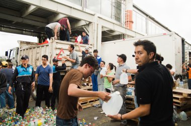 Quito, Ekvator - Nisan, 23, 2016: Afet Yardım gıda, giyim, ilaç ve su kıyılarında deprem kurtulanlar için sağlayan tanımlanamayan vatandaşlar Quito