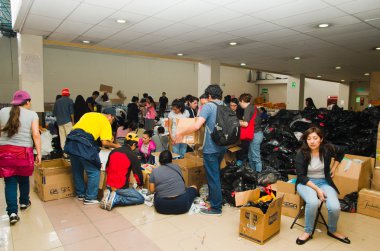 Quito, Ekvator - 23 Nisan 2016: Afet Yardım gıda, giyim, ilaç ve su kıyılarında deprem kurtulanlar için sağlayan tanımlanamayan vatandaşlar Quito