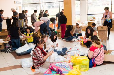 Quito, Ekvator - 23 Nisan 2016: Afet Yardım gıda, giyim, ilaç ve su kıyılarında deprem kurtulanlar için sağlayan tanımlanamayan vatandaşlar Quito