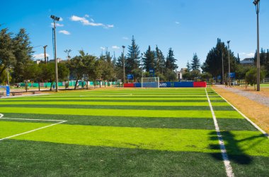 Quito, Ekvator - 8 Ağustos, 2016: futbol sahası iç şehirde bulunan park La Carolina, yapay yeşil çim yüzey, binalar görünür arka plan, güzel bir güneşli gün