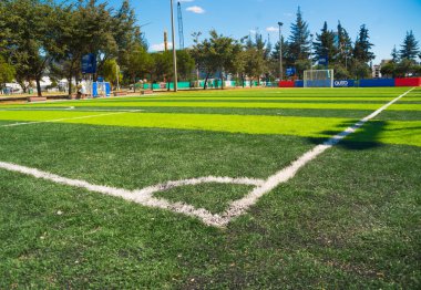 Quito, Ekvator - 8 Ağustos, 2016: suni çim futbol sahası, büyük bakış açısı bulunan şehir içi Park La Carolina, gösterilen ağaçlar ve Binalar, güzel bir güneşli gün köşe bayrak alınan