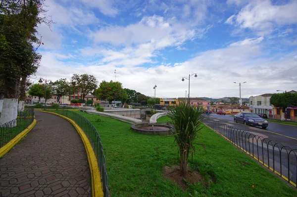 TULCAN, ECUADOR - 3 DE JULIO DE 2016: coche estacionado junto a un parque vacío en un día nublado — Foto de Stock