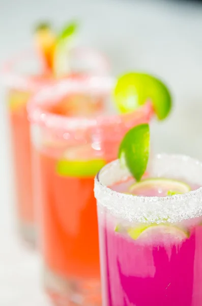 Closeup small sugarcoated shotglasses with delicious orange and purple juices inside — Stock Photo, Image