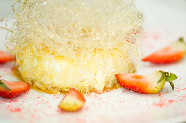 Closeup spectacular dessert, small white cake with snowflake type sugar decorations, strawberries lying around edges — Stock Photo, Image