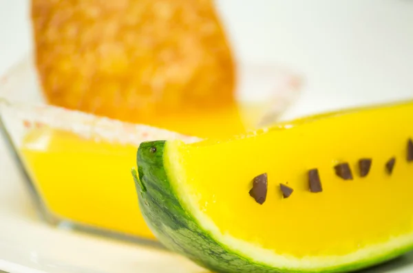 Melon skin with yellow frozen dessert in it and pieces of chocolate as decor — Stock Photo, Image