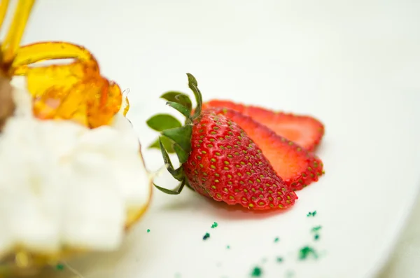 Bardzo elegancka Prezentacja kremowy deser z wystrojem chrupki cukier i truskawki, leżącego w przód — Zdjęcie stockowe