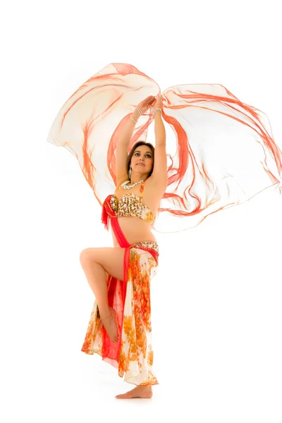 Bellydancer wearing red and brown colored top with skirt, holding veil in hands performing dance, white studio background — Stock Photo, Image