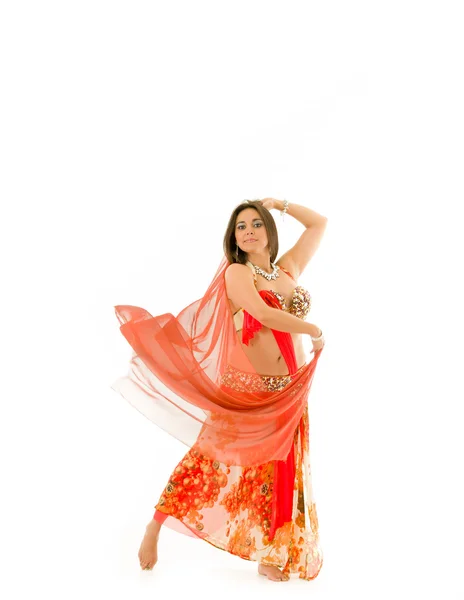 Bellydancer wearing red and brown colored top with skirt, holding veil in hands performing dance, white studio background — Stock Photo, Image