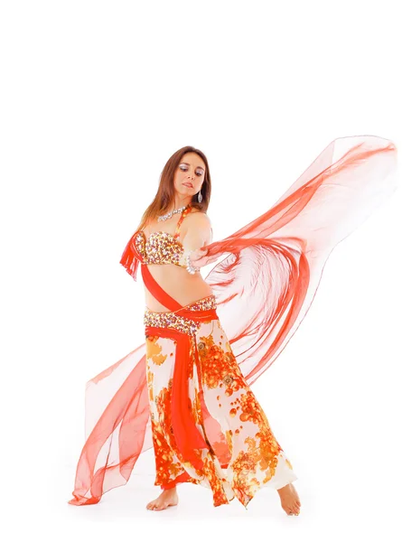 Bellydancer wearing red and brown colored top with skirt, holding veil in hands performing dance, white studio background — Stock Photo, Image