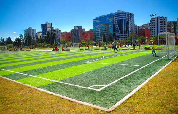 Quito, Ecuador - 8 augusti 2016: fotbollsplaner ligger i innerstaden park La Carolina, grönt konstgräs yta, byggnader synlig bakgrund, vacker solig dag — Stockfoto