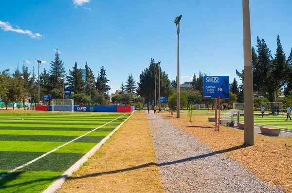 Quito, Ecuador - 8 augusti 2016: fotbollsplaner ligger i innerstaden park La Carolina, grönt konstgräs yta, byggnader synlig bakgrund, vacker solig dag — Stockfoto